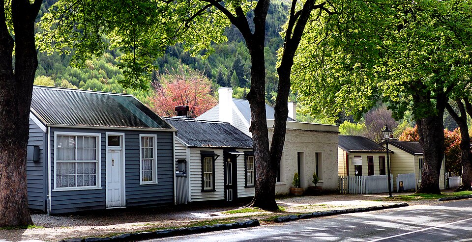 Historic cottages beneath leafy trees in Arrowtown New Zealand