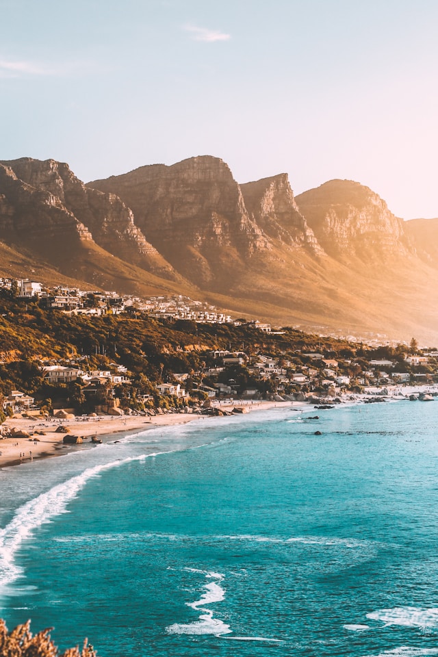 Golden sunset over Camps Bay beach with the Twelve Apostles mountain range