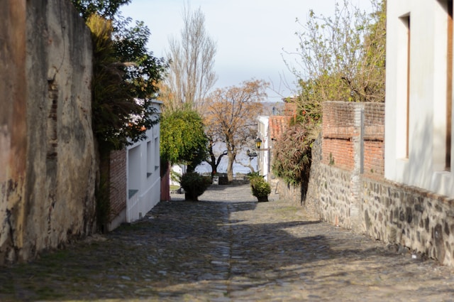 Calle de los Suspiros, a narrow cobblestone street with stone walls leading toward the Río de la Plata in Colonia del Sacramento