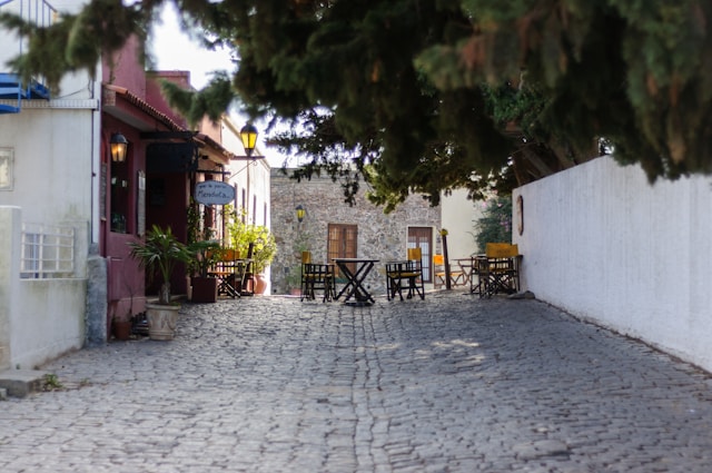 Outdoor café tables and chairs arranged along a cobblestone street in Colonia del Sacramento