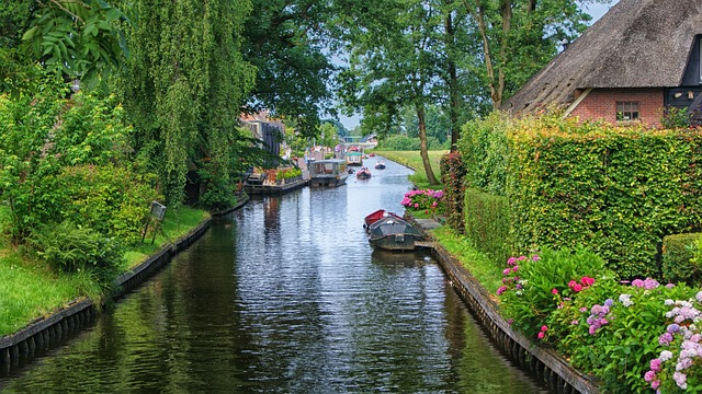 Traditional boat traveling through a canal in Giethoorn Netherlands