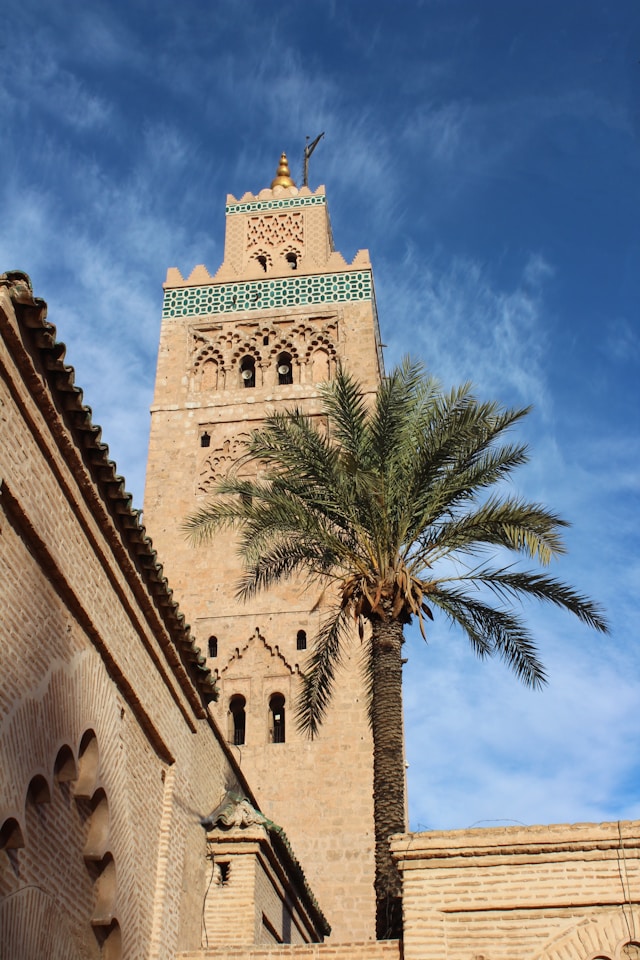 Historic Koutoubia Mosque minaret rising above Marrakech against a blue sky