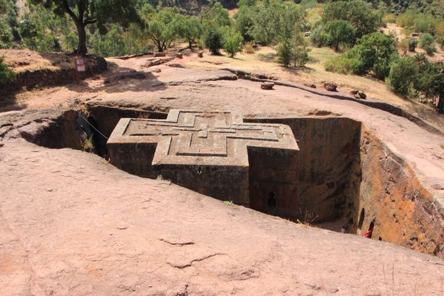 Aerial view of the cross-shaped Church of Saint George cut into volcanic rock