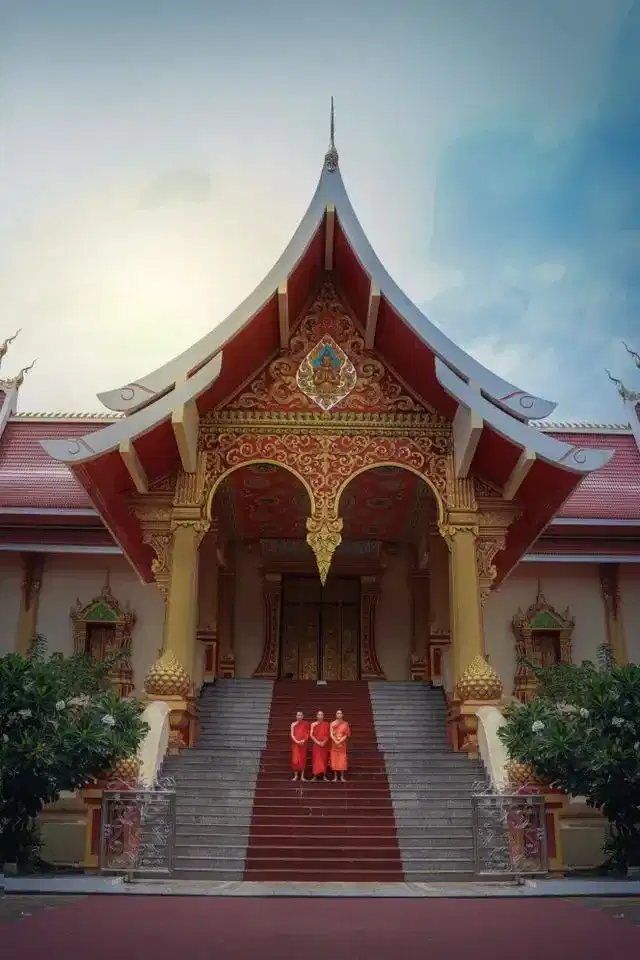 Young Buddhist monks standing on temple steps in Laos