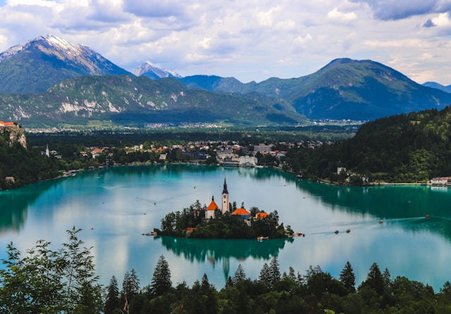 Lake Bled island church surrounded by turquoise water and Alpine mountains, Slovenia — travel resources for European destinations