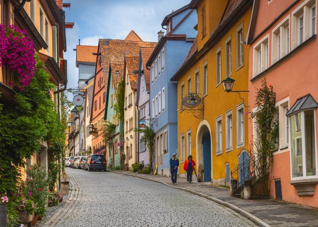 Colorful pastel houses lining a quiet cobbled street in Rothenburg ob der Tauber