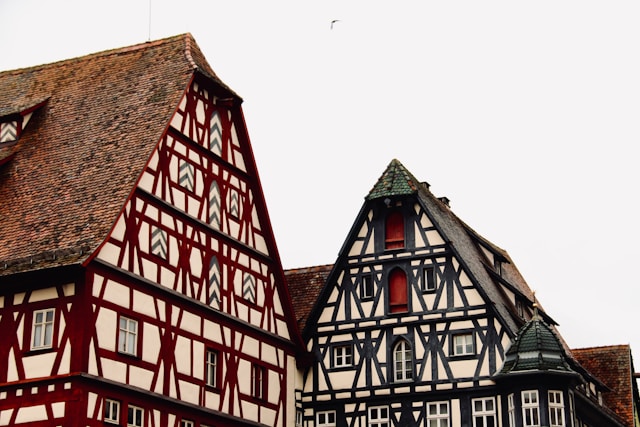 Decorative gables of two adjoining half-timbered houses in Rothenburg ob der Tauber against a pale sky