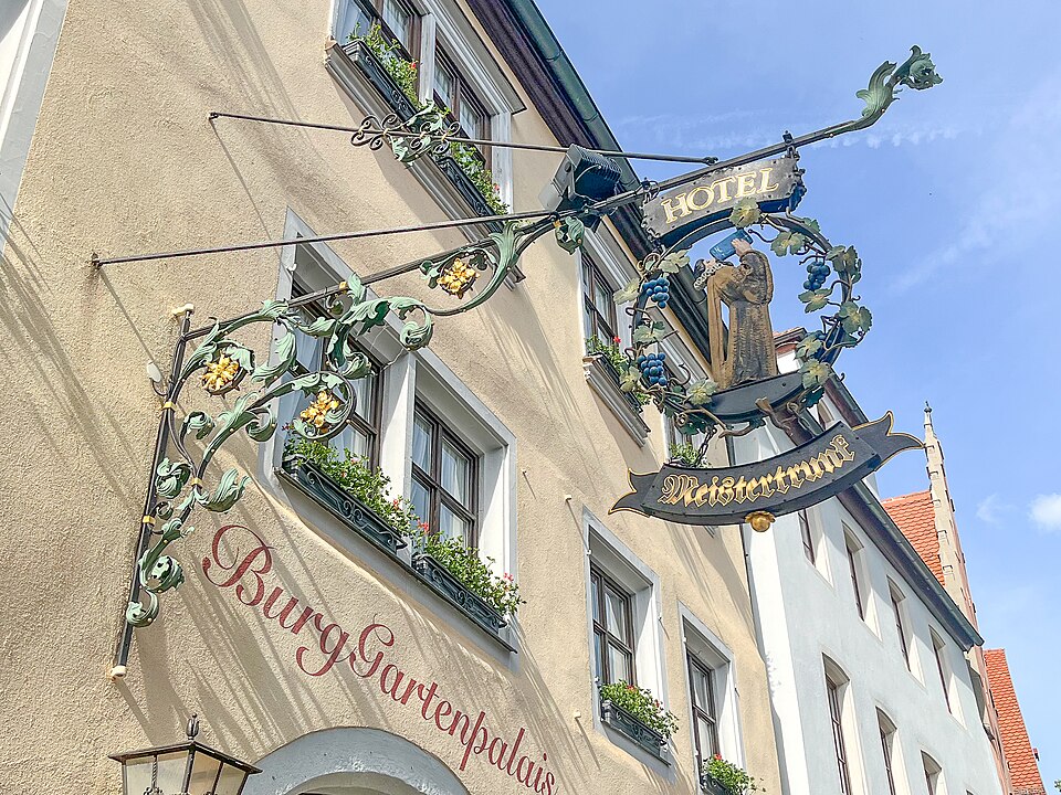 Wrought-iron Hotel Meistertrunk sign with a drinking figure in Rothenburg ob der Tauber