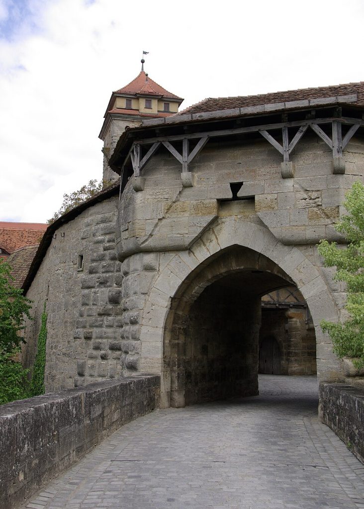 A pointed-arch gateway of the Spitalbastei in Rothenburg ob der Tauber with a cobbled road passing through