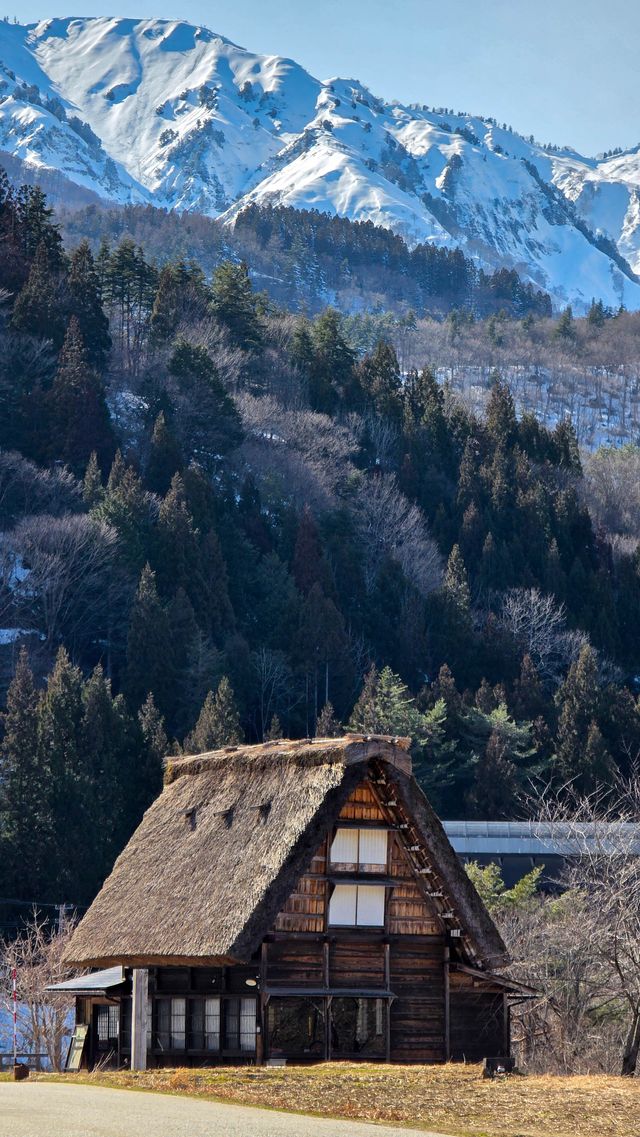 Traditional gassho-zukuri house with snow-capped mountains in Shirakawa-go Japan