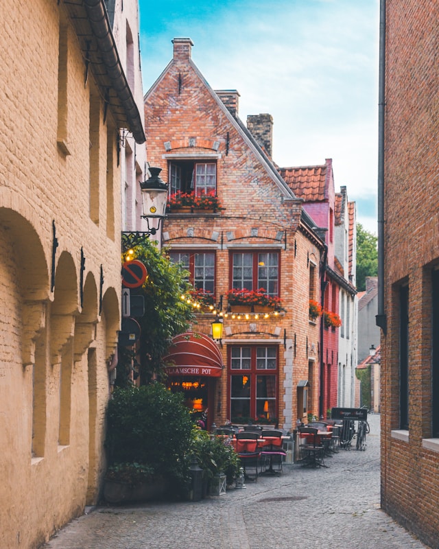 Narrow alley decorated with string lights and flowers in Bruges Belgium