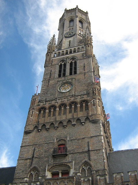Close-up of the Belfry of Bruges bell tower against a blue sky