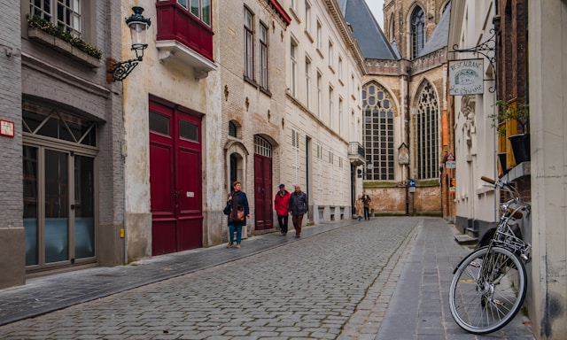 Cobblestone street leading toward a Gothic cathedral in Bruges Belgium