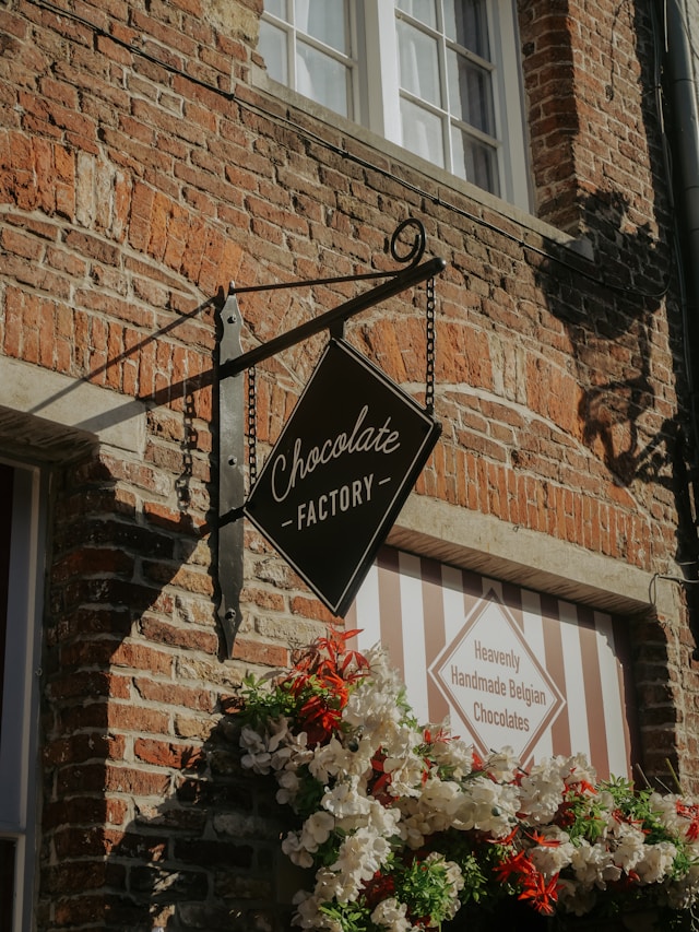 Chocolate Factory sign above a flower-lined shop window
