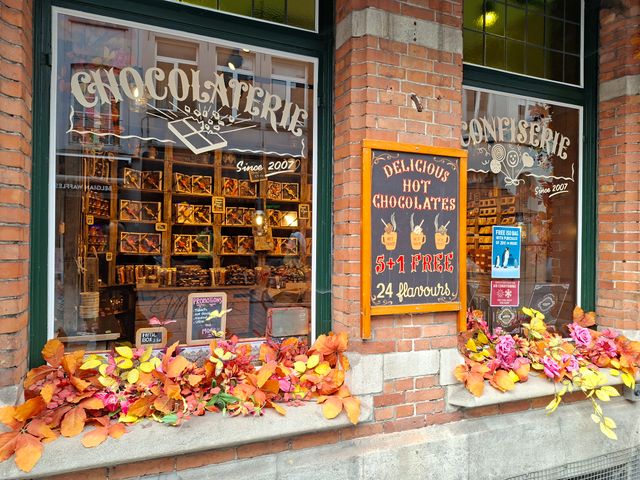 Chocolaterie Confiserie shop window decorated with autumn flowers