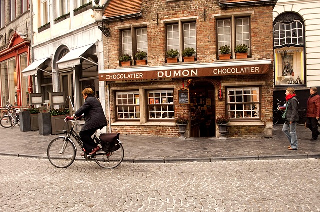 Woman cycling past the DUMON Chocolatier corner shop