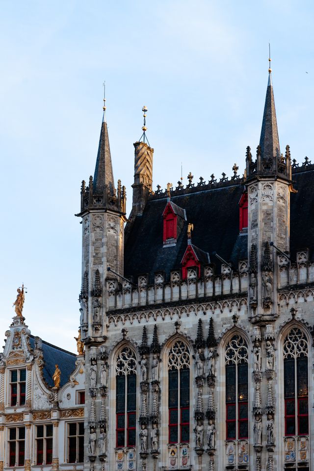 Gothic spires and stonework of a historic building in Bruges Belgium