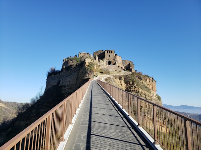 A long pedestrian bridge leading up to a hilltop village, Civita di Bagnoregio Italy