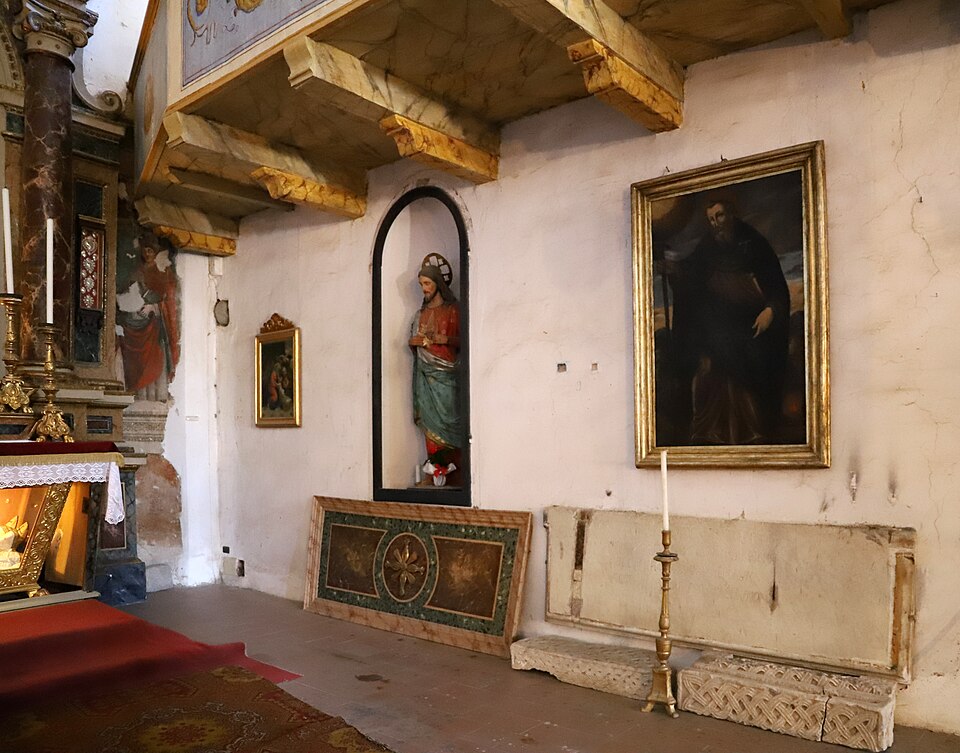 A side chapel with a statue niche and framed paintings