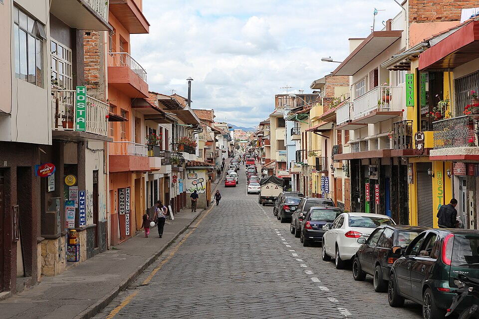 A colonial street lined with hostels and parked cars