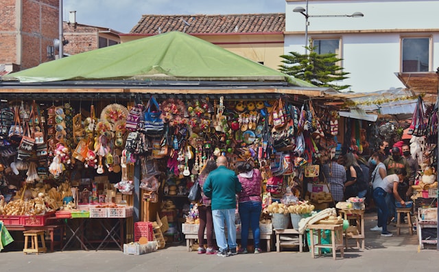A souvenir stall packed with woven bags, hats, and handmade crafts