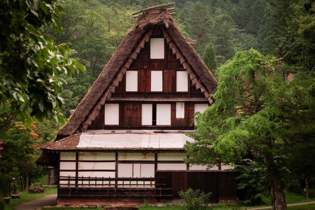 Traditional gassho-zukuri house surrounded by green trees