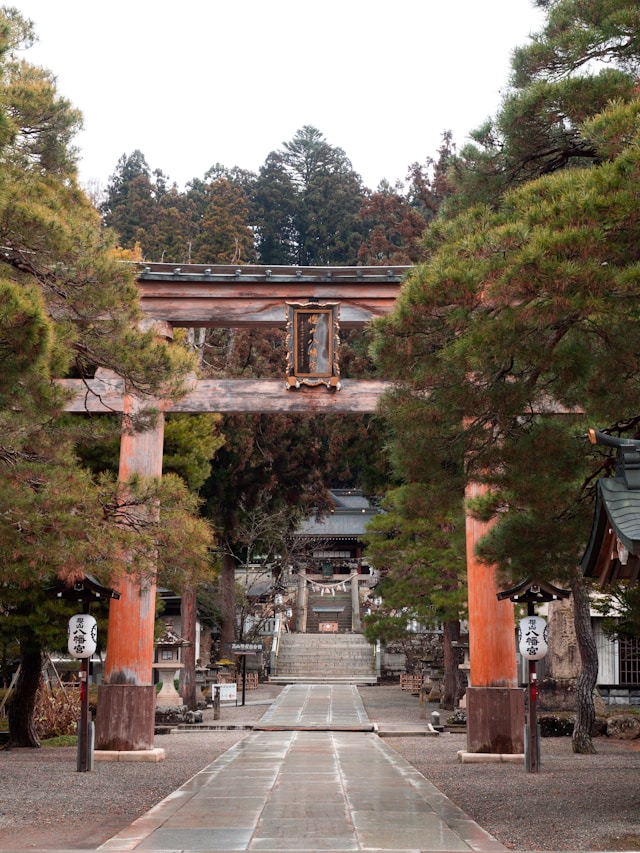 Stone walkway leading through a torii gate to a Takayama shrine