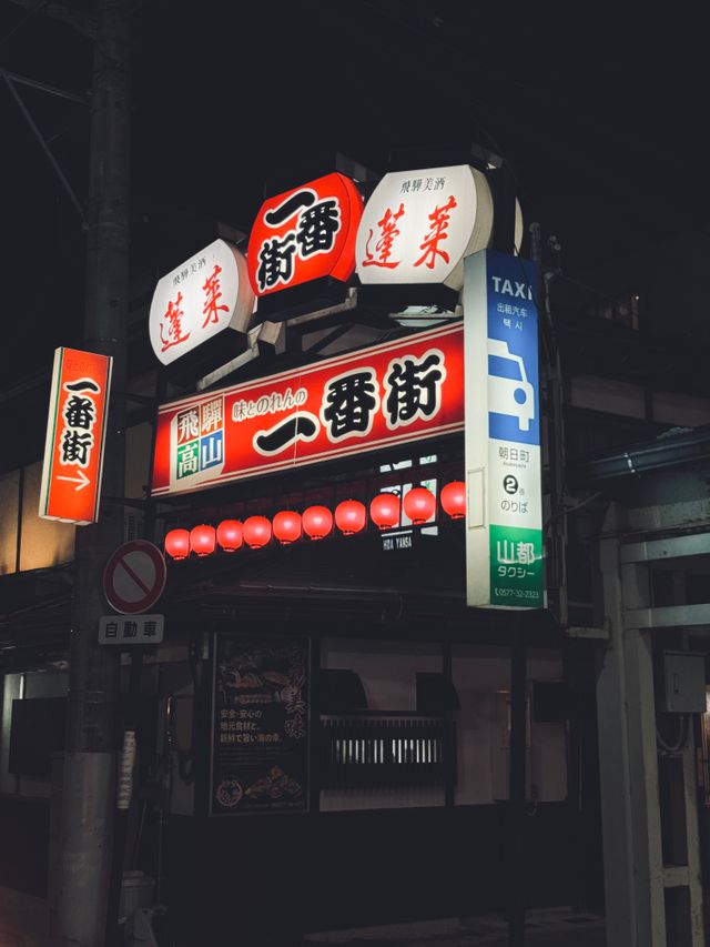 Illuminated red signage at a market entrance at night