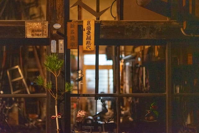 Warmly lit interior of a traditional shop seen through a dark wooden facade