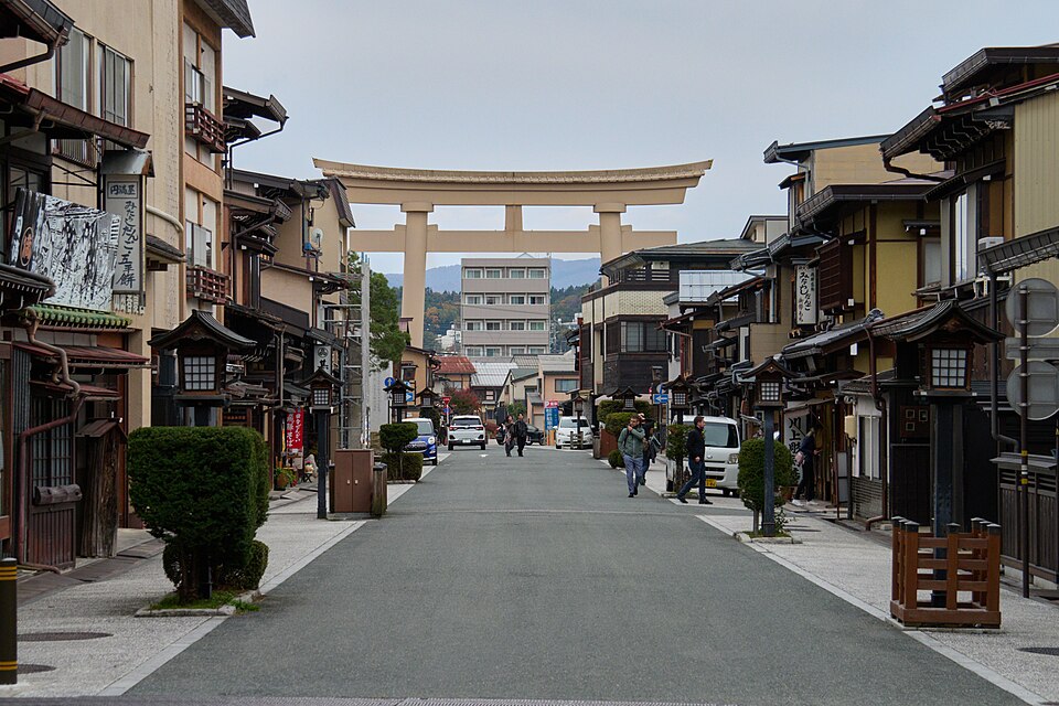 Traditional merchant street in Takayama leading toward a large torii gate