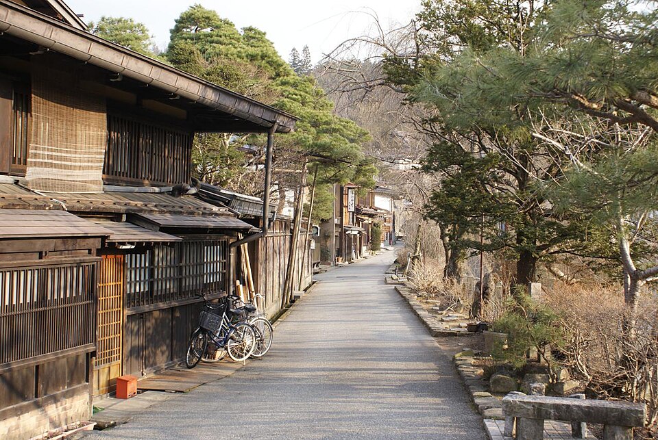 Bicycles parked along a quiet street of traditional wooden houses