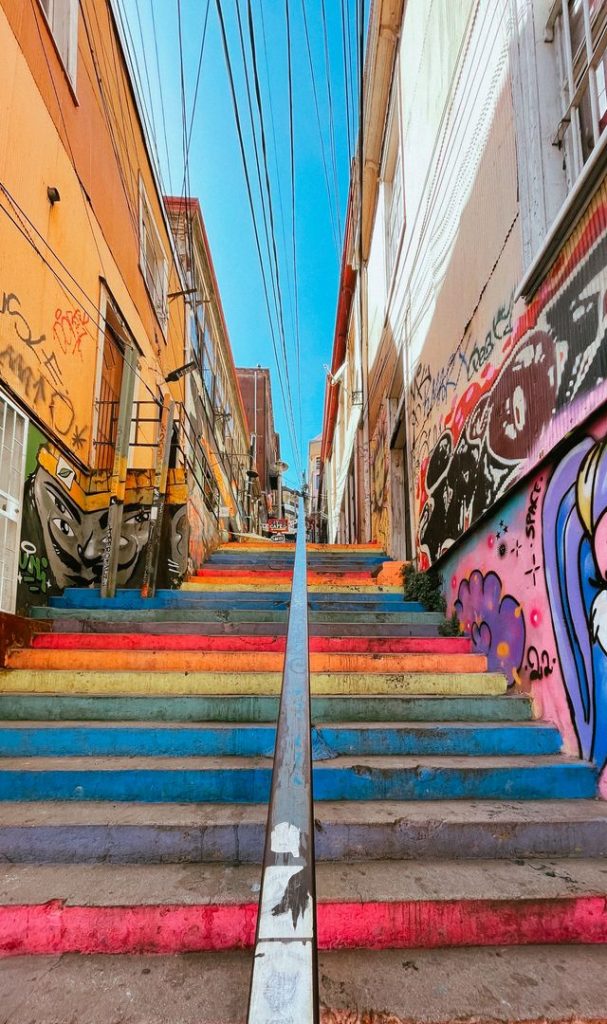 A straight staircase painted in bands of red, yellow, green, and blue