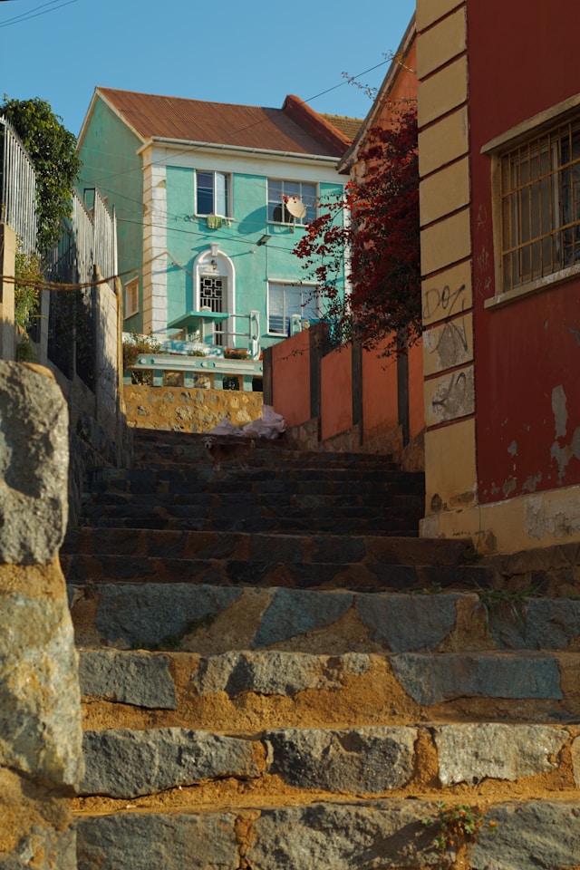 Worn stone steps leading up toward a teal-colored house in Valparaiso Chile
