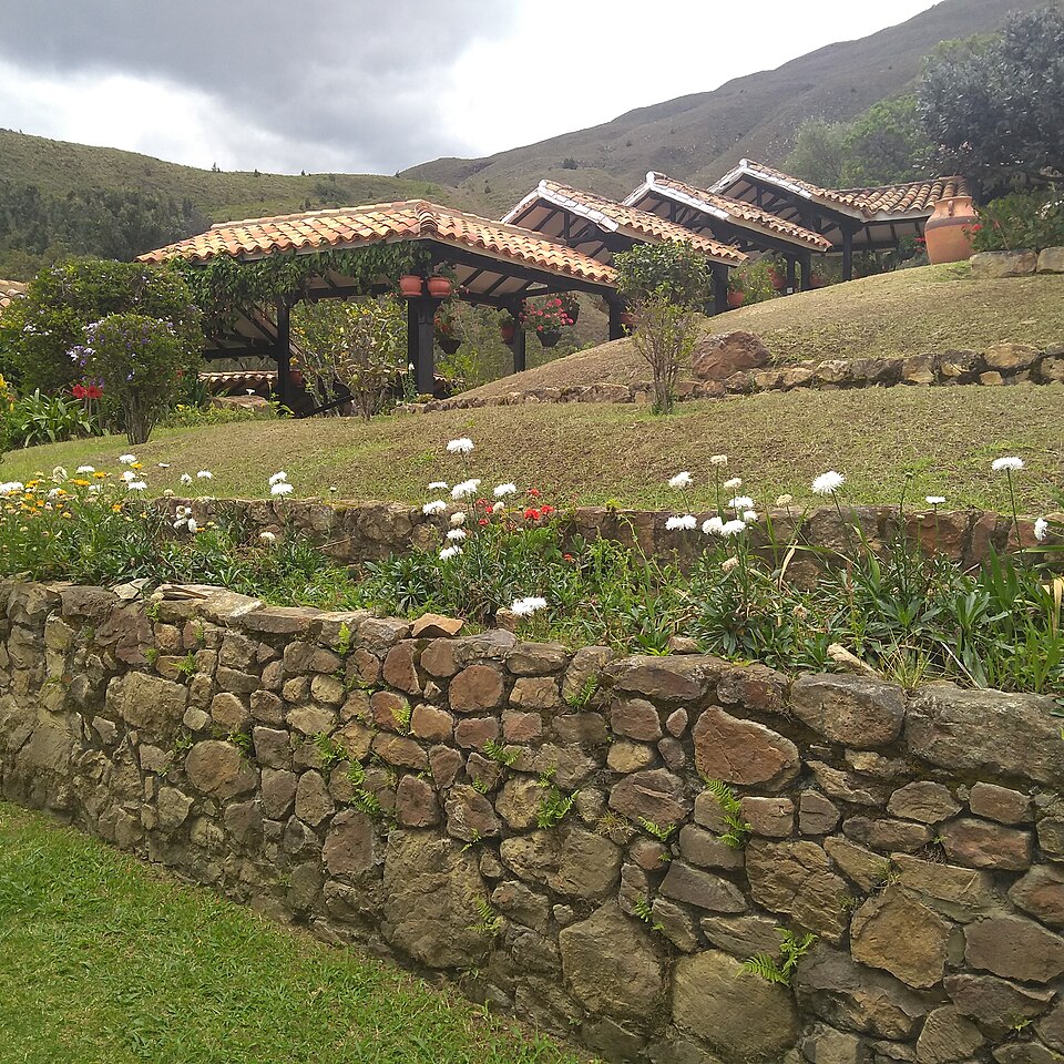 Terraced garden with stone walls and terracotta roofed gazebos