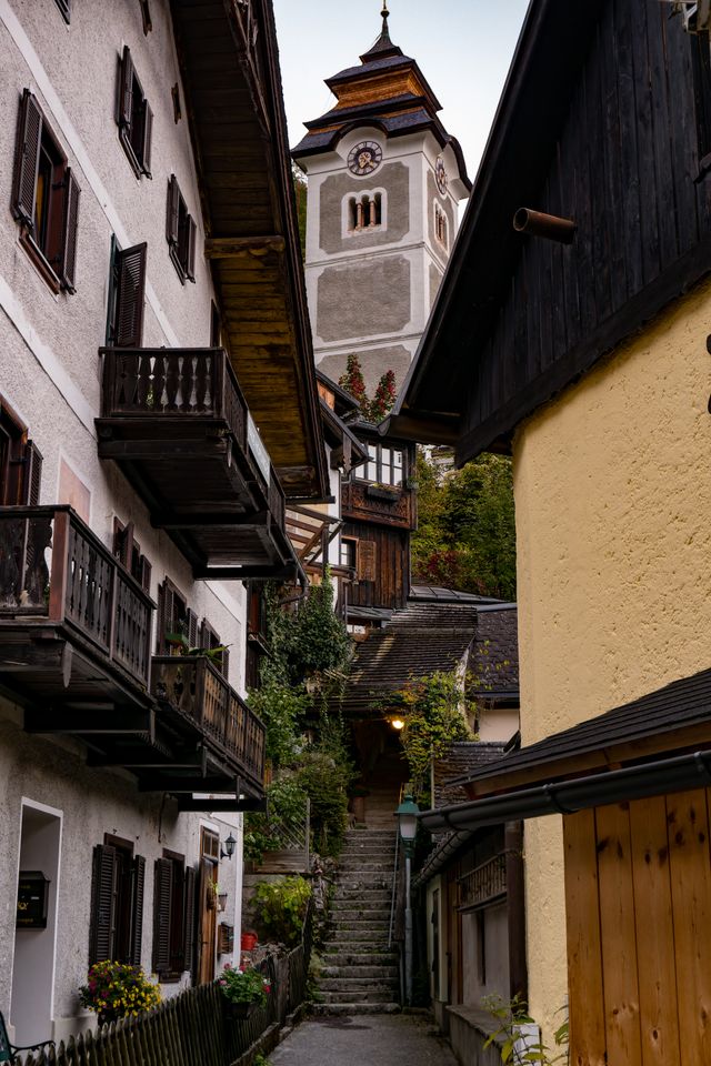 A narrow Hallstatt alley leading toward the church clock tower