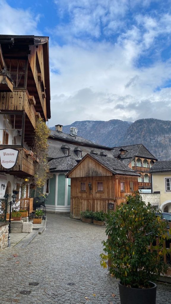 A cobblestone street lined with traditional wooden guesthouses in Hallstatt