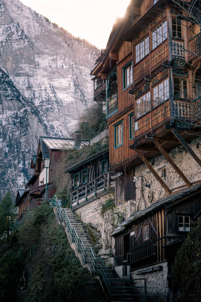 Wooden balconied houses on Hallstatt's steep hillside lit by golden morning light