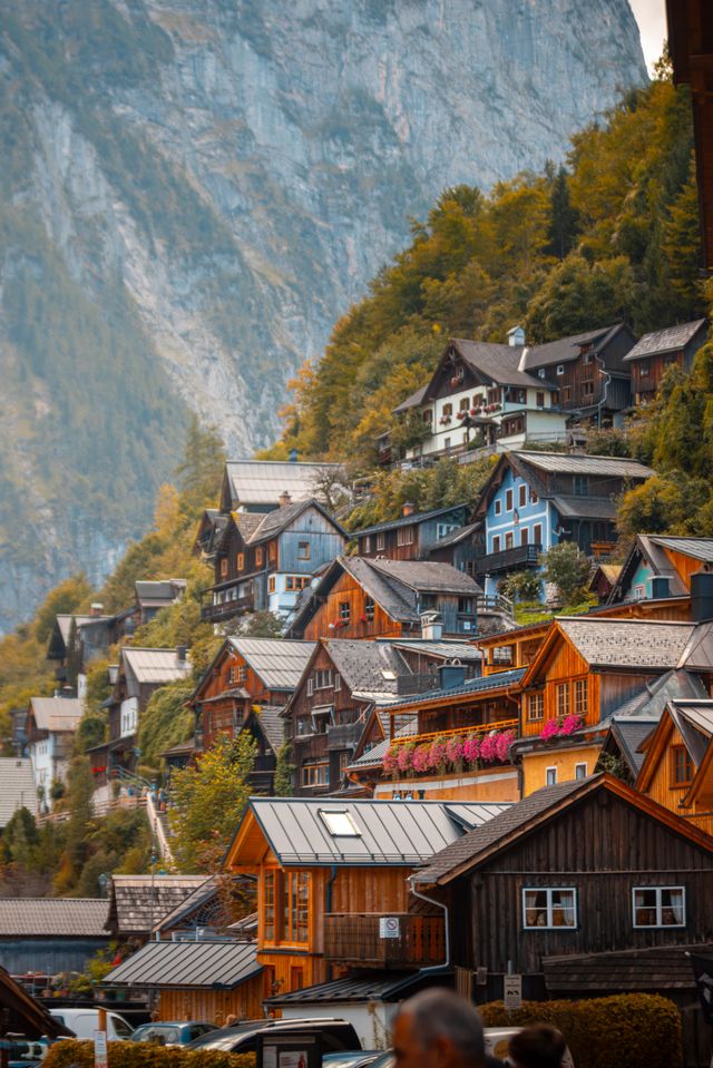Colorful houses with flower filled balconies climbing Hallstatt's hillside