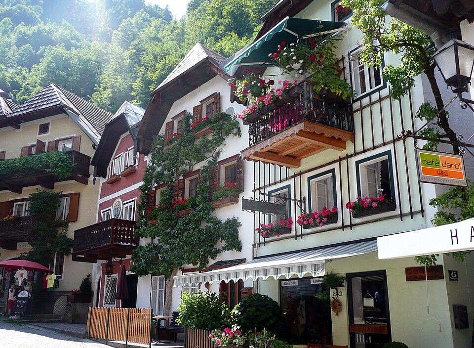 Flower draped balconies along a sunny street in Hallstatt's market area