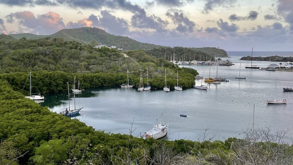 A sheltered bay with moored boats surrounded by green hills
