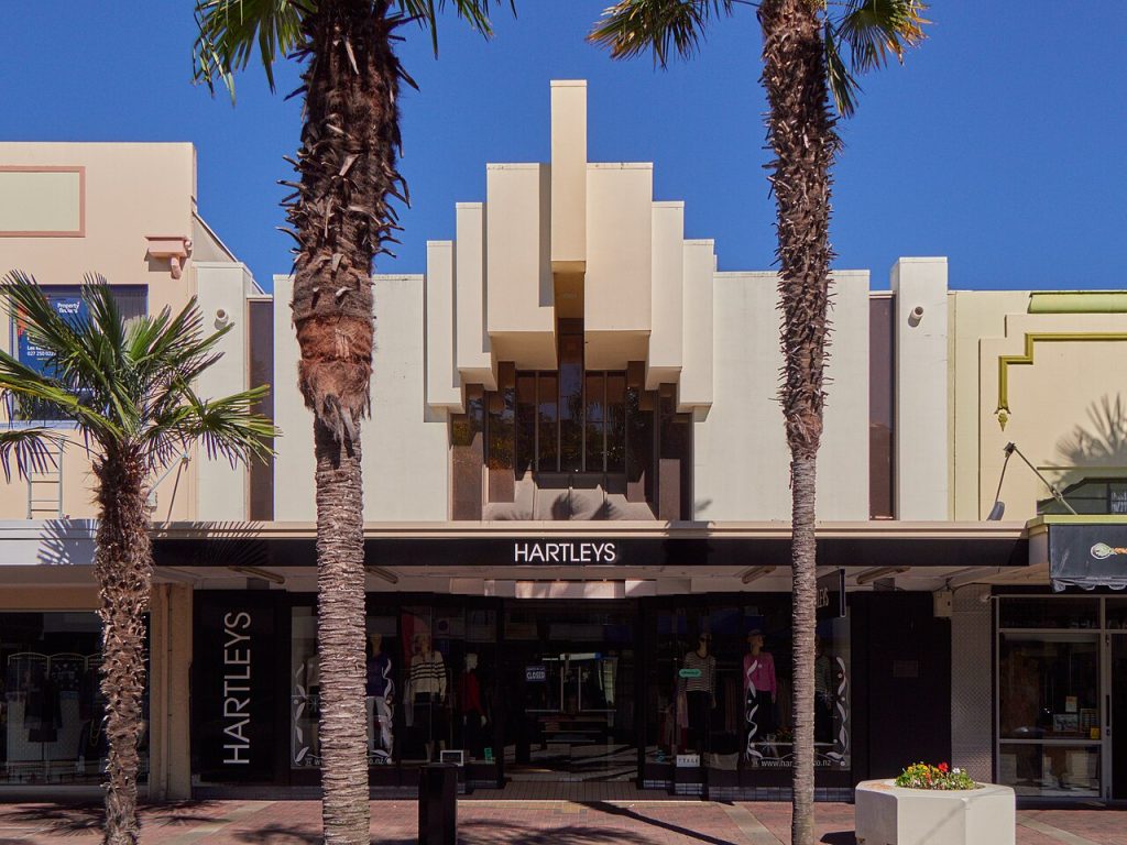 A cream Art Deco facade framed by palm trees