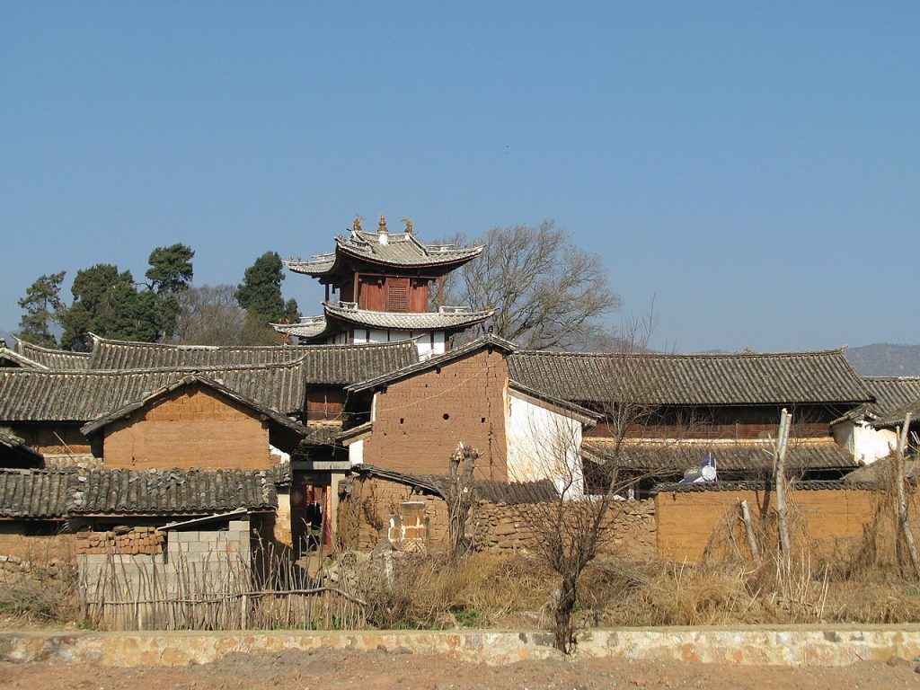 Tiled rooftops and a pagoda tower in a Bai village