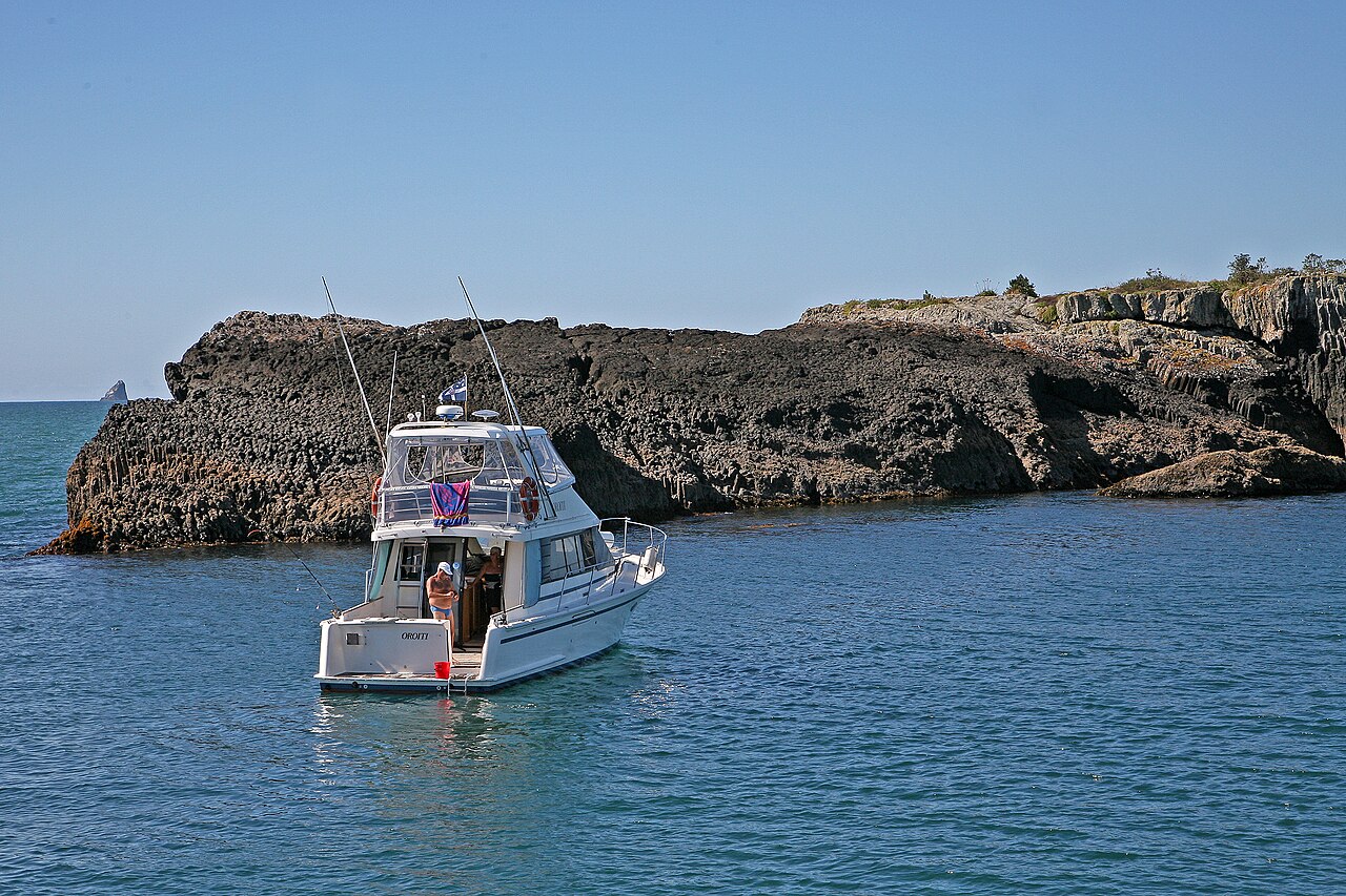 Boat anchored beside rocky islands in the Bay of Islands near Russell New Zealand
