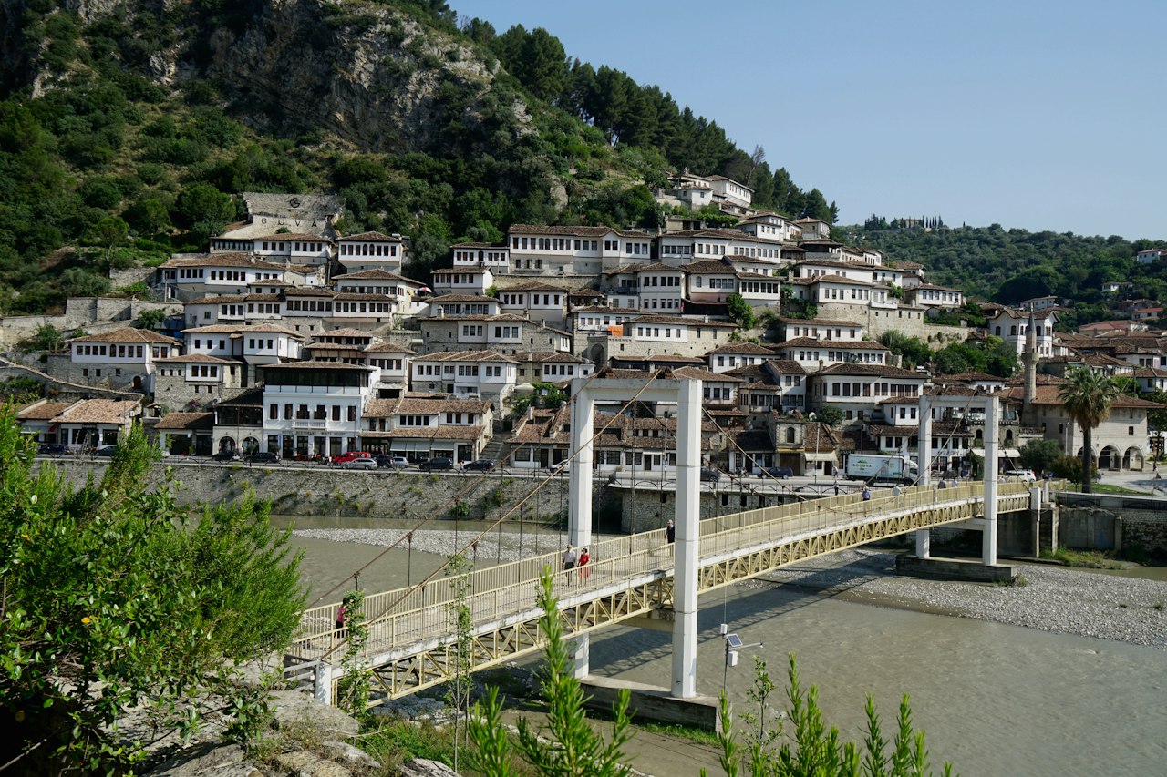 Stone bridge over the river with old houses beyond