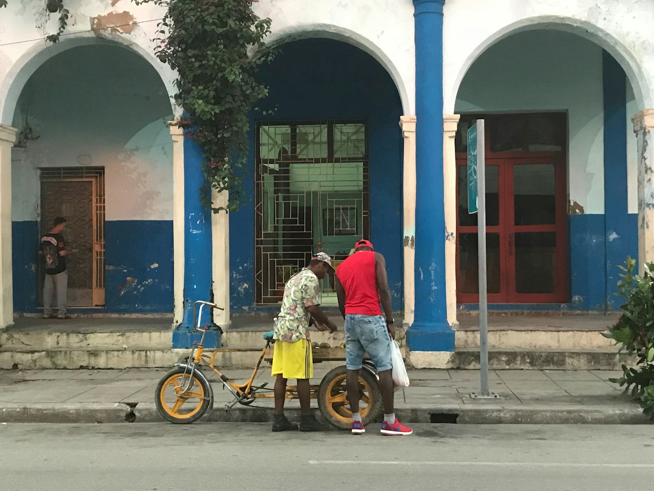 Two men with a bicycle on a colonial street