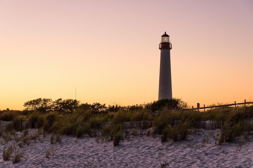 Cape May Lighthouse silhouetted against an orange sunset