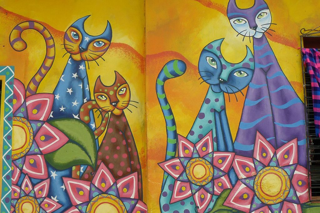 Painted cats in bright colors on a town wall