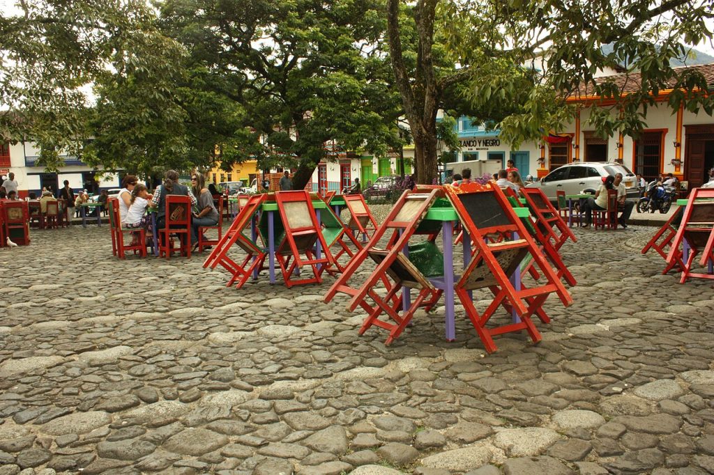 Brightly painted wooden chairs and tables on the main plaza