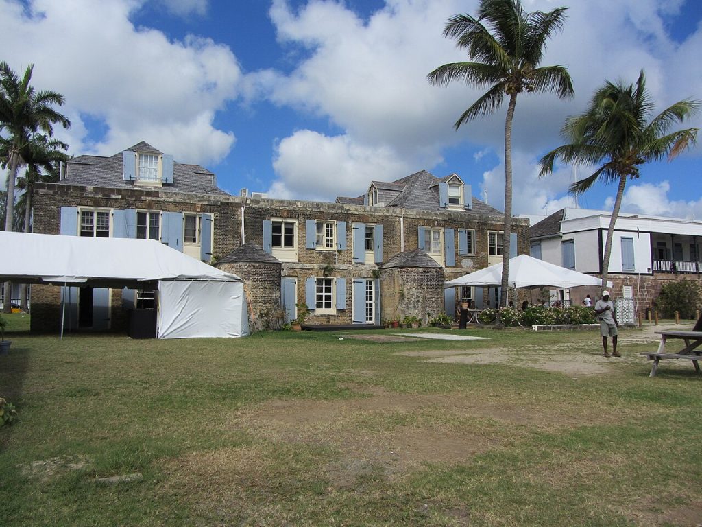 Historic stone and timber buildings around a lawn in the dockyard