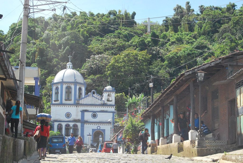 A cobbled street leading to the white El Calvario church